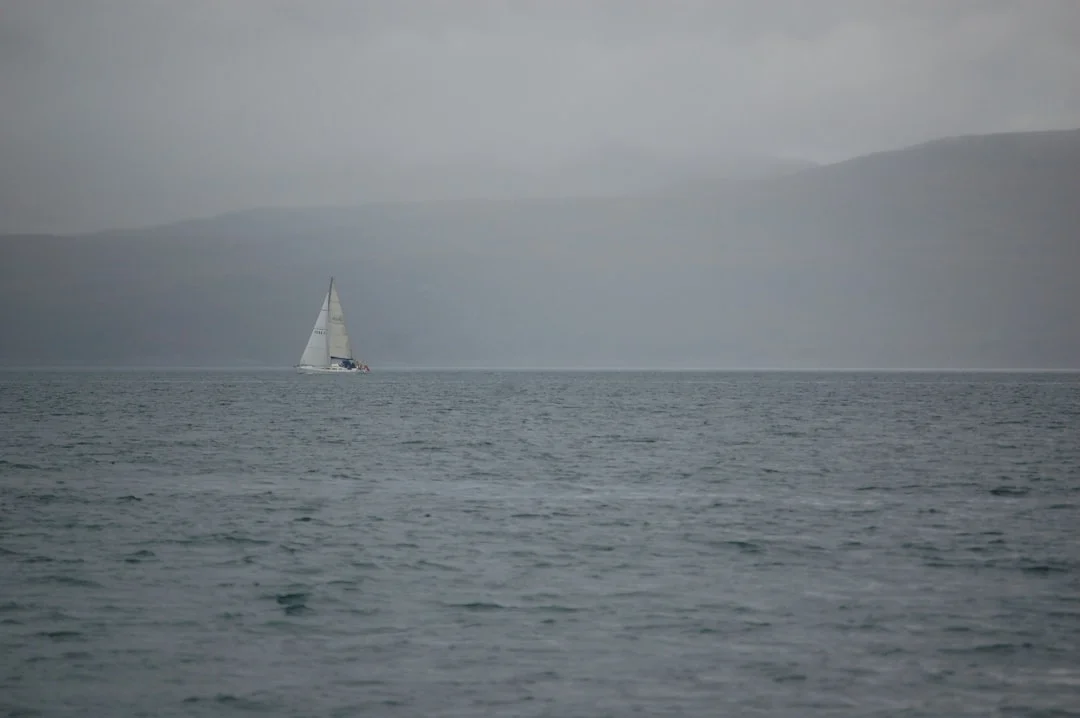 Sailboat cruising across open ocean waters with sails trimmed