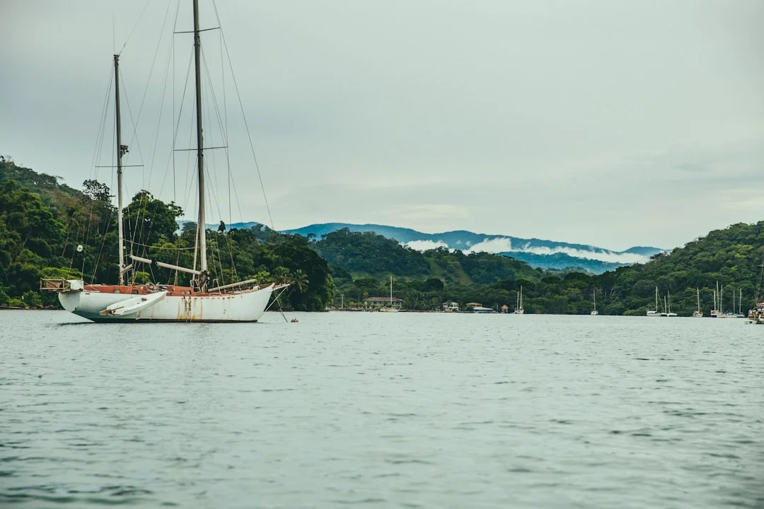 Sailboat heeling on open ocean with dramatic cloud formations overhead