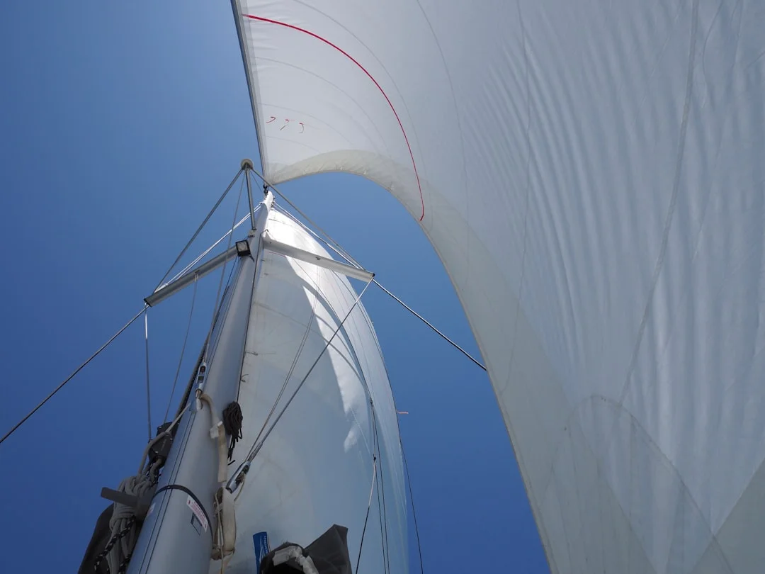 Sailboat heeling under wind with blue sky