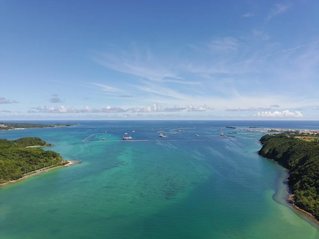 Boats anchored in a clear turquoise bay surrounded by lush green islands in the Caribbean