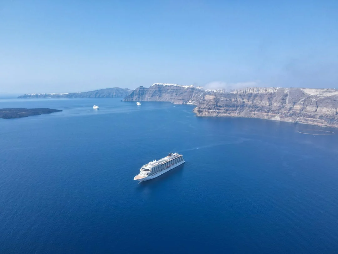 Aerial drone view of the Santorini caldera with deep blue water and volcanic cliffs