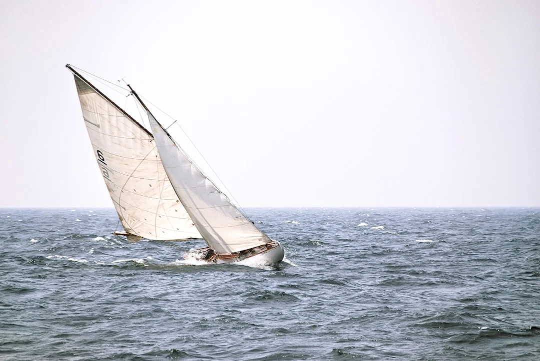 Vintage sailing yacht heeling hard under full sail in strong wind during a race