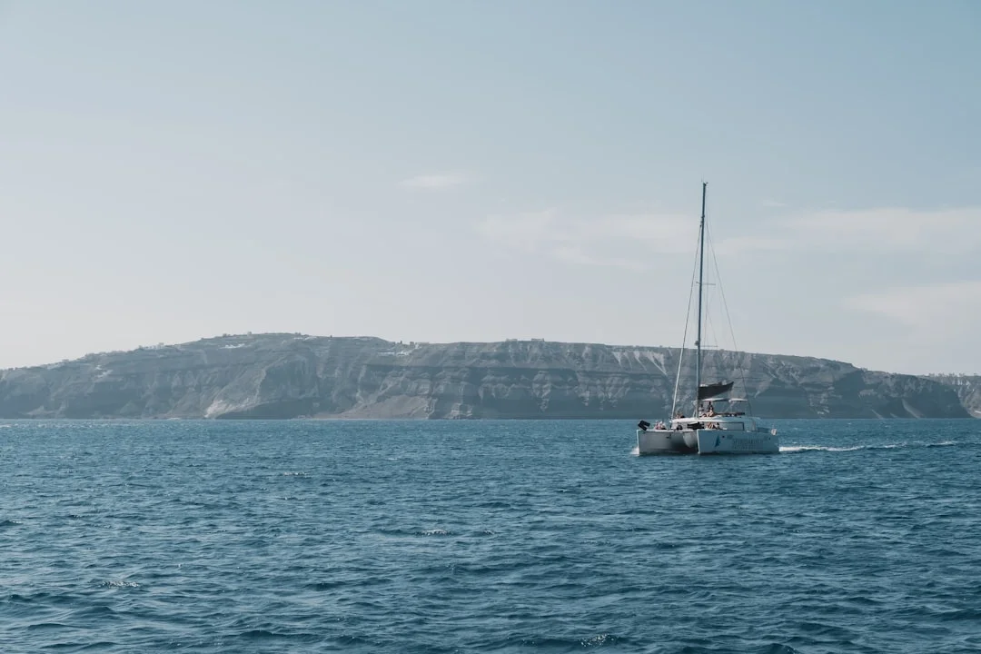 White catamaran sailing on open blue water