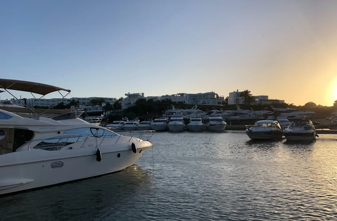 Yachts moored in a sheltered harbour surrounded by Mediterranean architecture