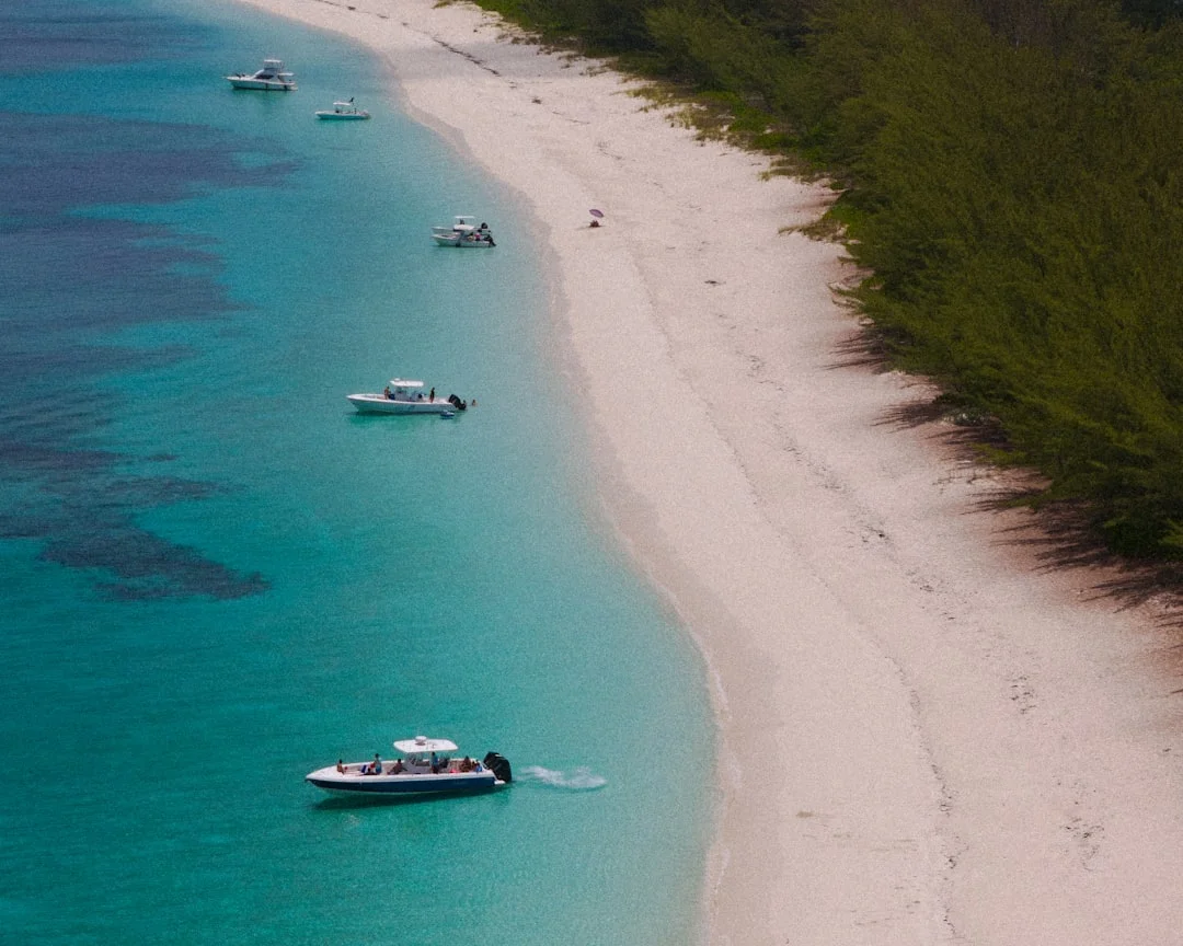 Boats on a beautiful Bahamas beach with crystal-clear turquoise water