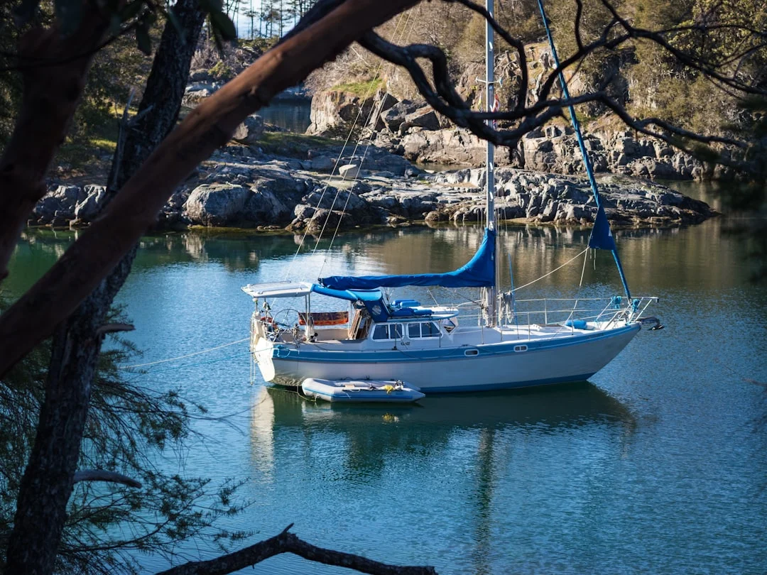 White sailboat at anchor on calm blue water