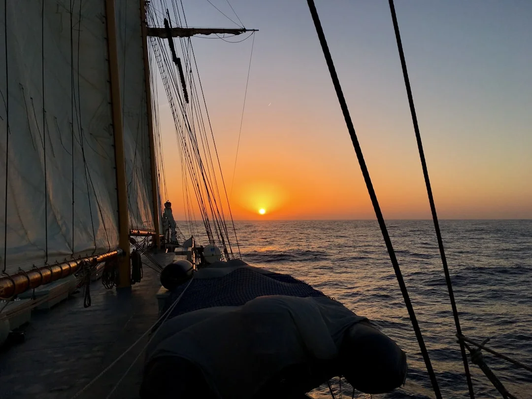 Golden sunset seen from the deck of a sailing vessel on the open ocean