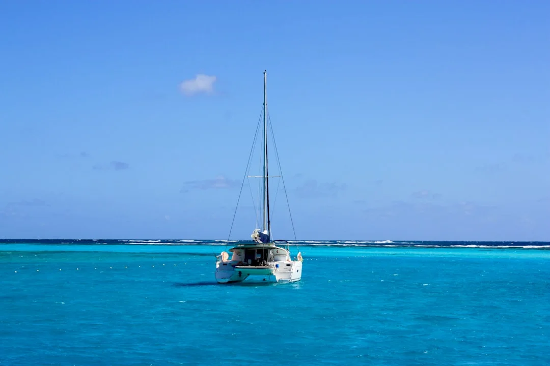 White catamaran sailing on bright turquoise Caribbean water