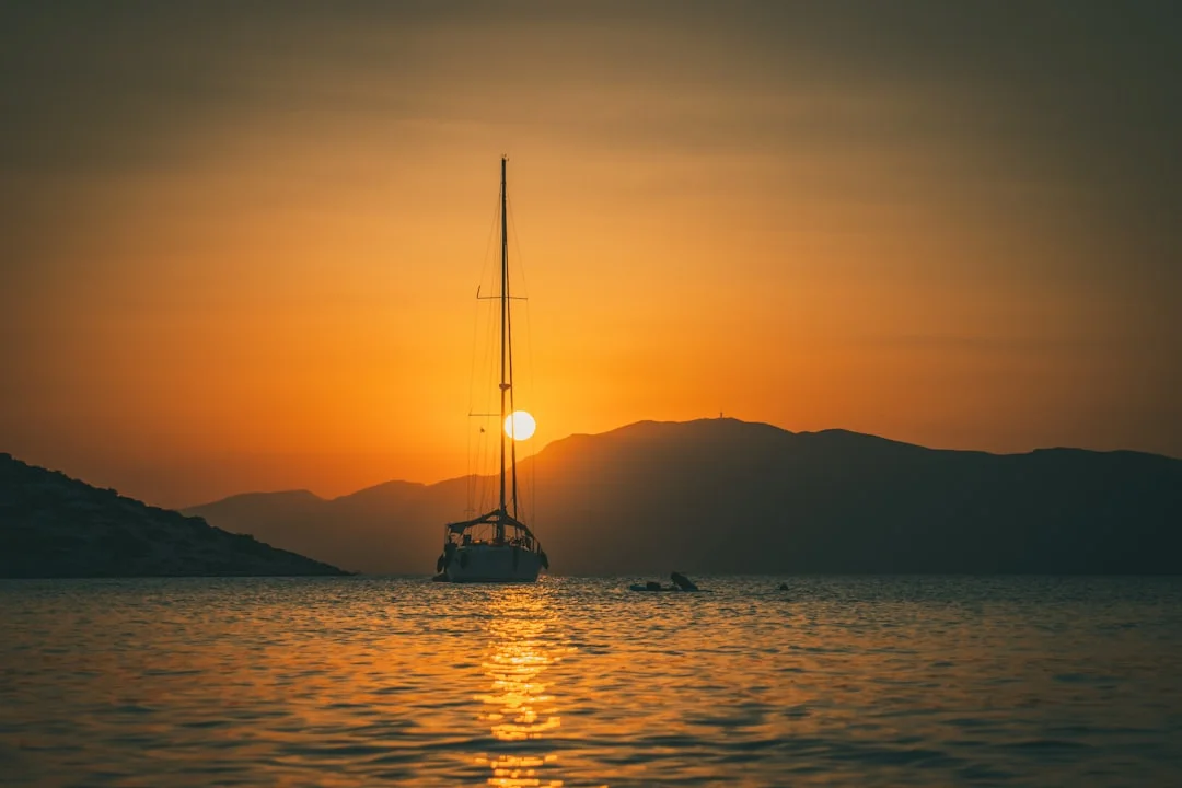 Sailboat anchored in golden light at sunset