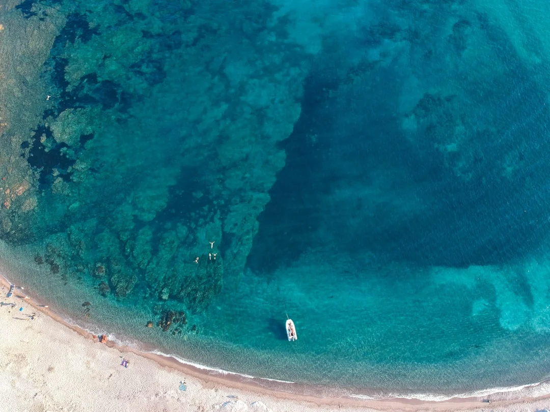 Aerial view of a yacht in a Corsica turquoise cove