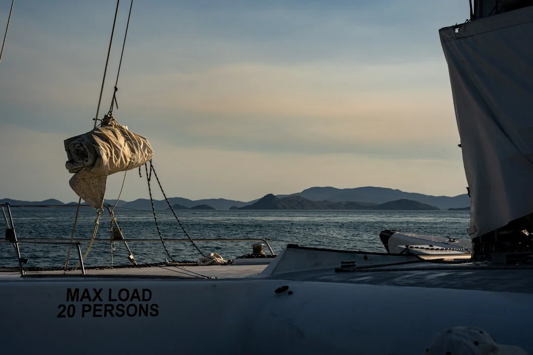 Sailboat anchored beneath green island peaks in the Whitsundays