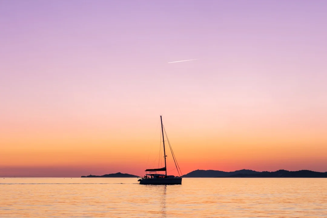 Sailboat anchored in a calm bay at sunset