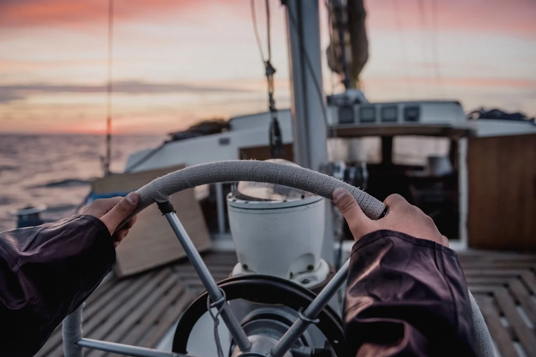 Skipper steering a sailing yacht at the helm