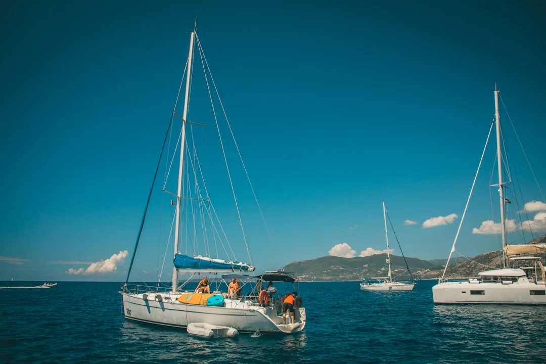Sailing yachts cruising through clear blue Greek island waters