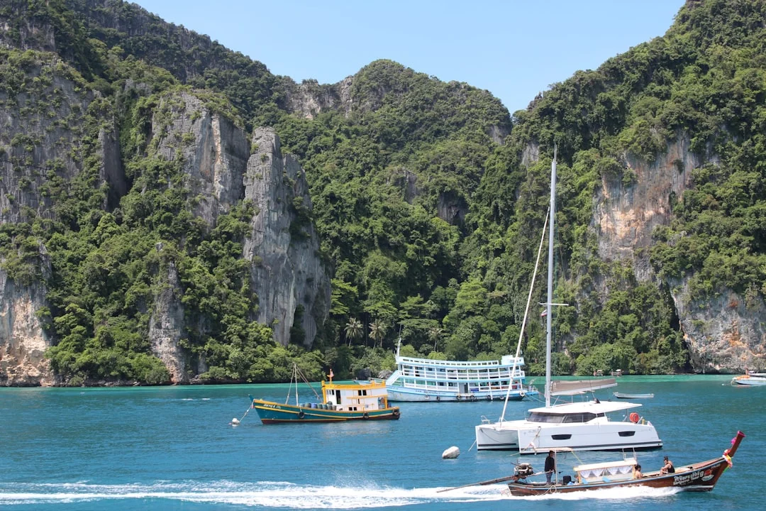 Sailboats anchored among limestone karst islands in the Andaman Sea