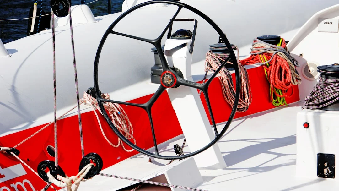 Close-up of a sailboat steering wheel with ocean in the background
