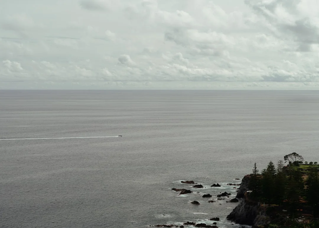 Boat anchored near rocky volcanic shore in the Azores islands