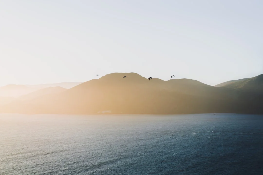 Sailboat anchored near volcanic mountains in the Pacific