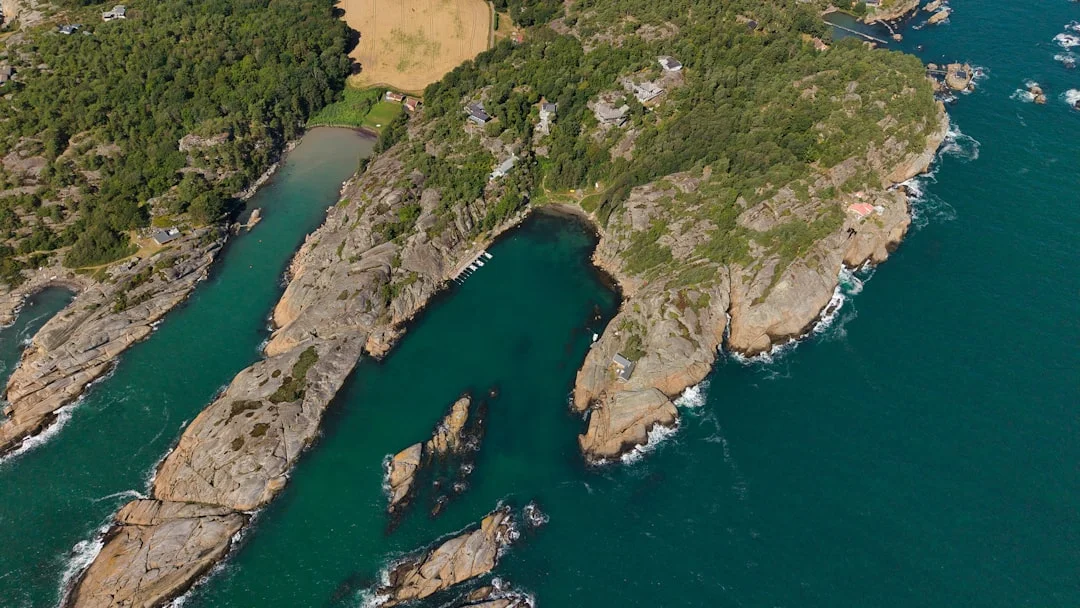 Aerial view of rocky coastline meeting turquoise water on the Swedish west coast