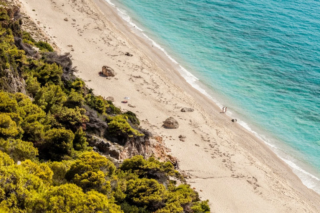Anchored yacht in clear water over sand/weed patches, snorkeler checking set