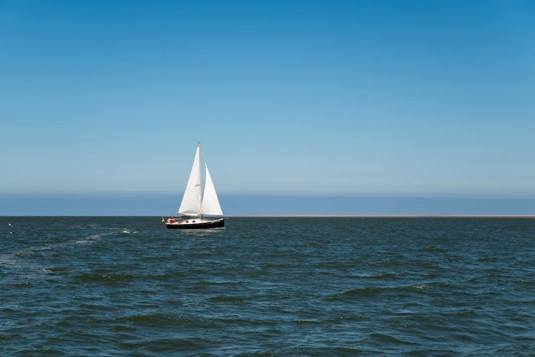 Sailboat crossing open ocean on a long passage at sunrise
