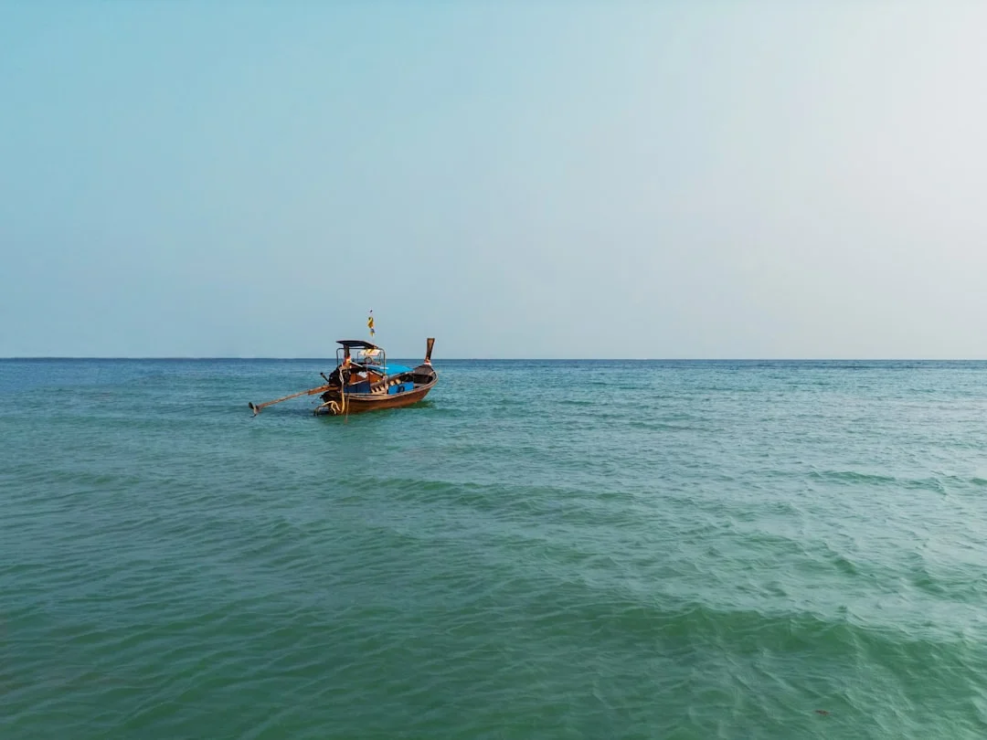 Thai long-tail boat sailing in turquoise water off Phuket