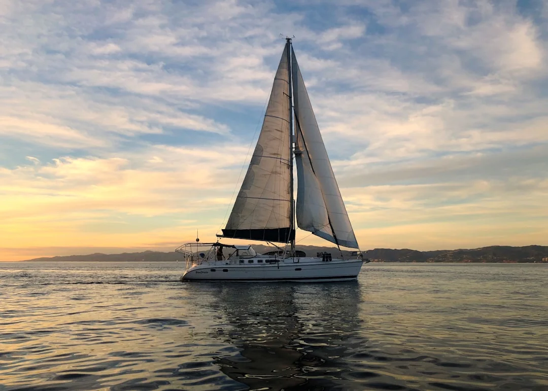 Catamaran under sail on open water during daytime with both hulls visible