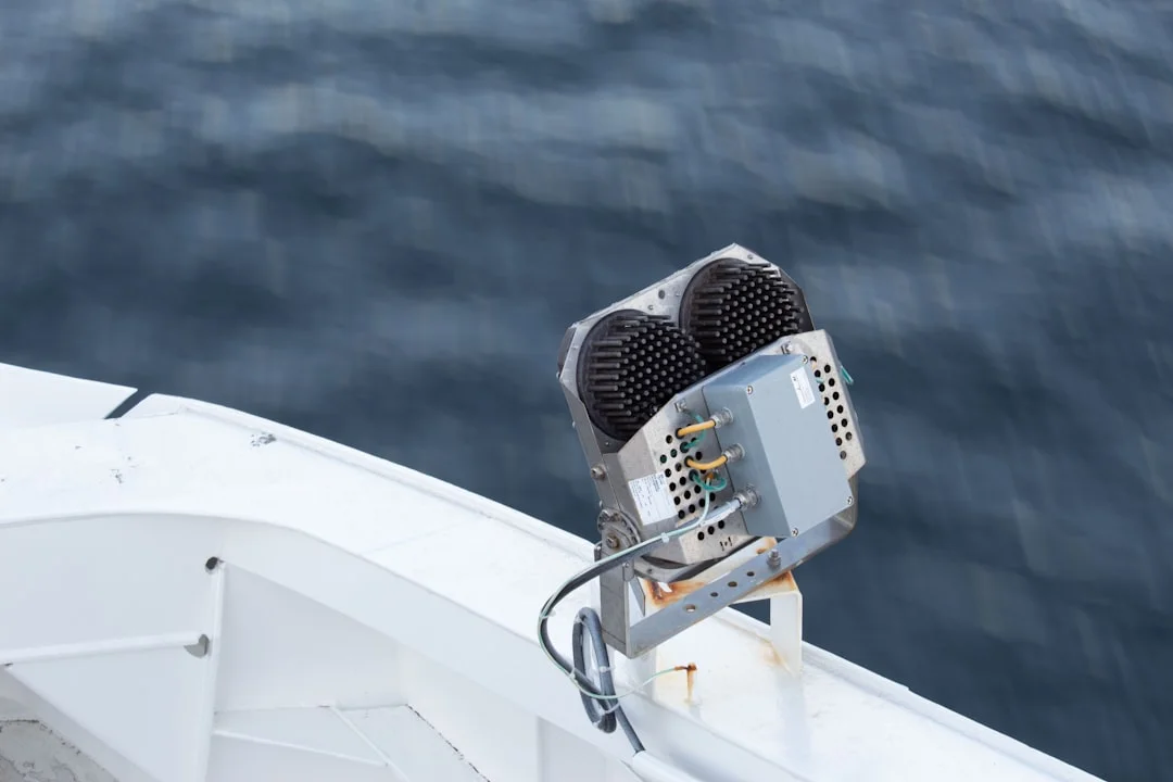 Chartplotter with VHF overlay and channel list taped near helm
