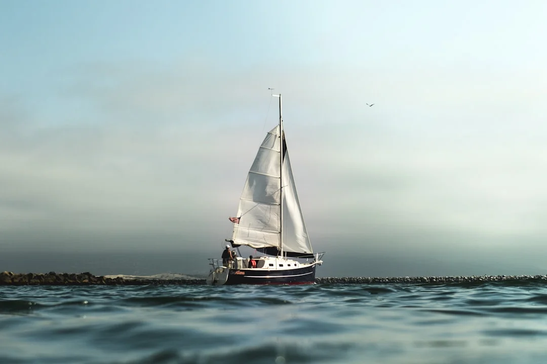 Small sailboat on open water for offshore communications planning