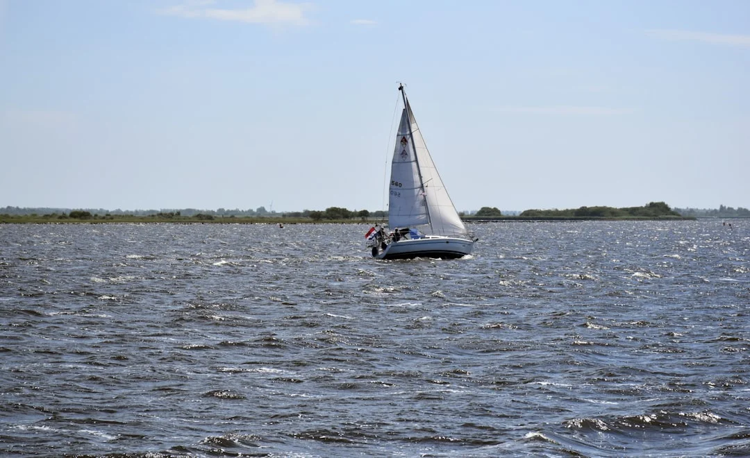 Sailing boat cruising on open sea during a sunny day