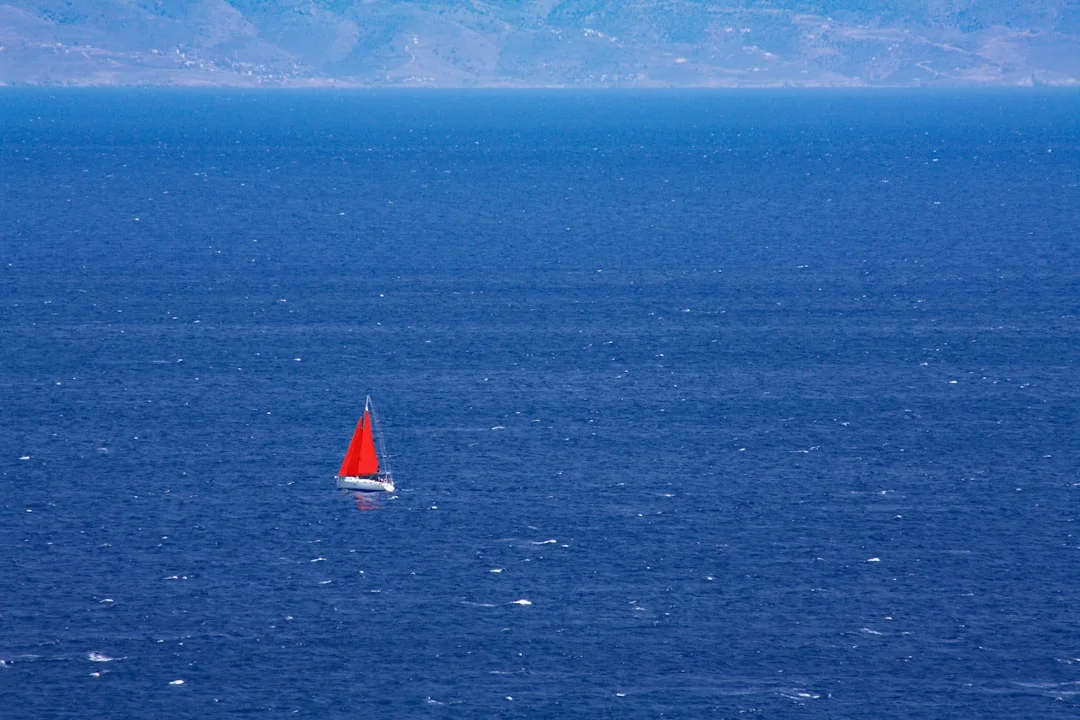 Idyllic turquoise cove along the southern coast of Turkey with a sailboat anchored in calm waters