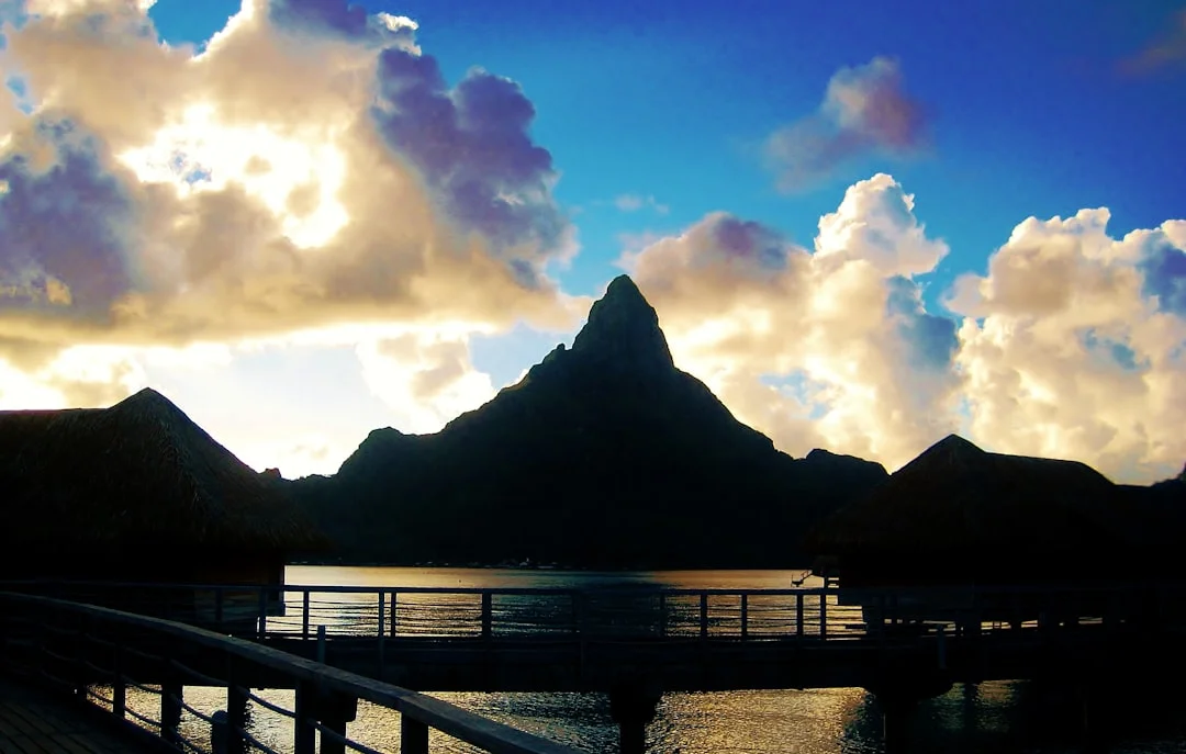 Sunrise approach toward Huahine—reefed main, squall line in distance