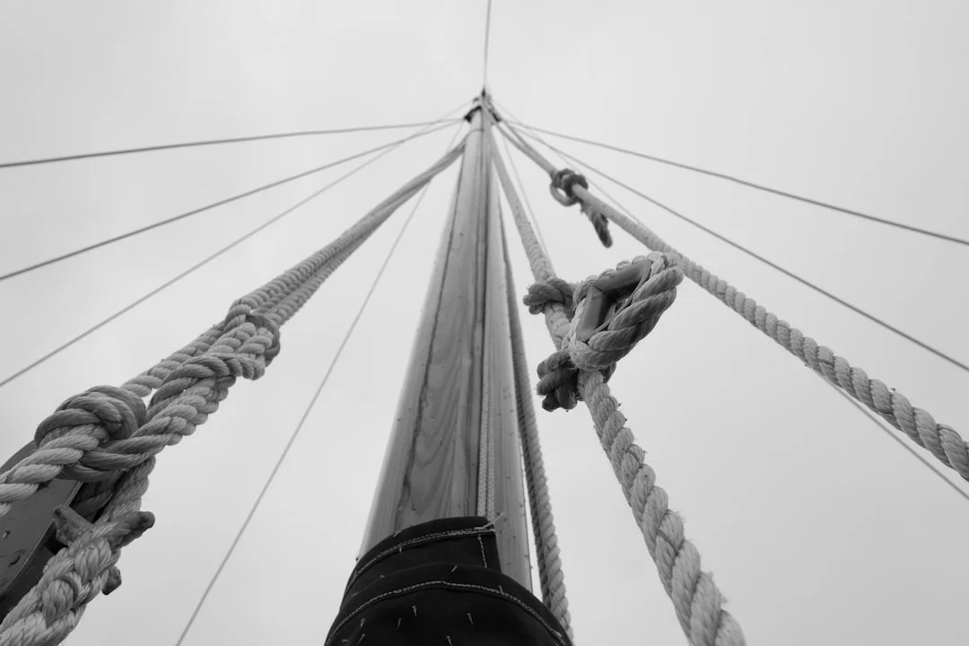 Mast laid down in slings with rigging labeled and coiled