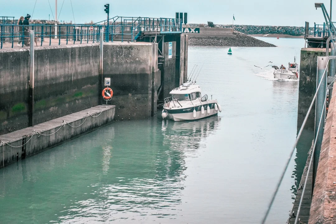 Fender board deployed between a yacht and a rough lock wall, with two lines securing the board