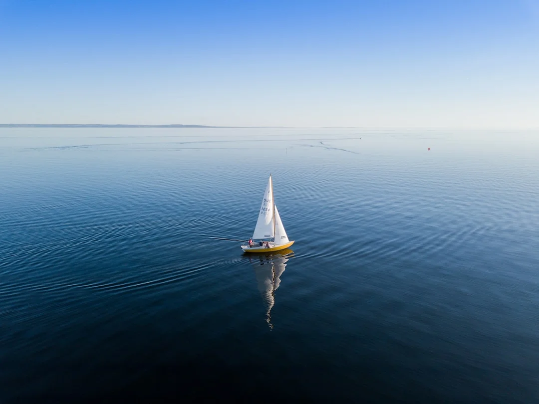 sailboat alongside dock in blow-on wind, fenders compressed and spring line set