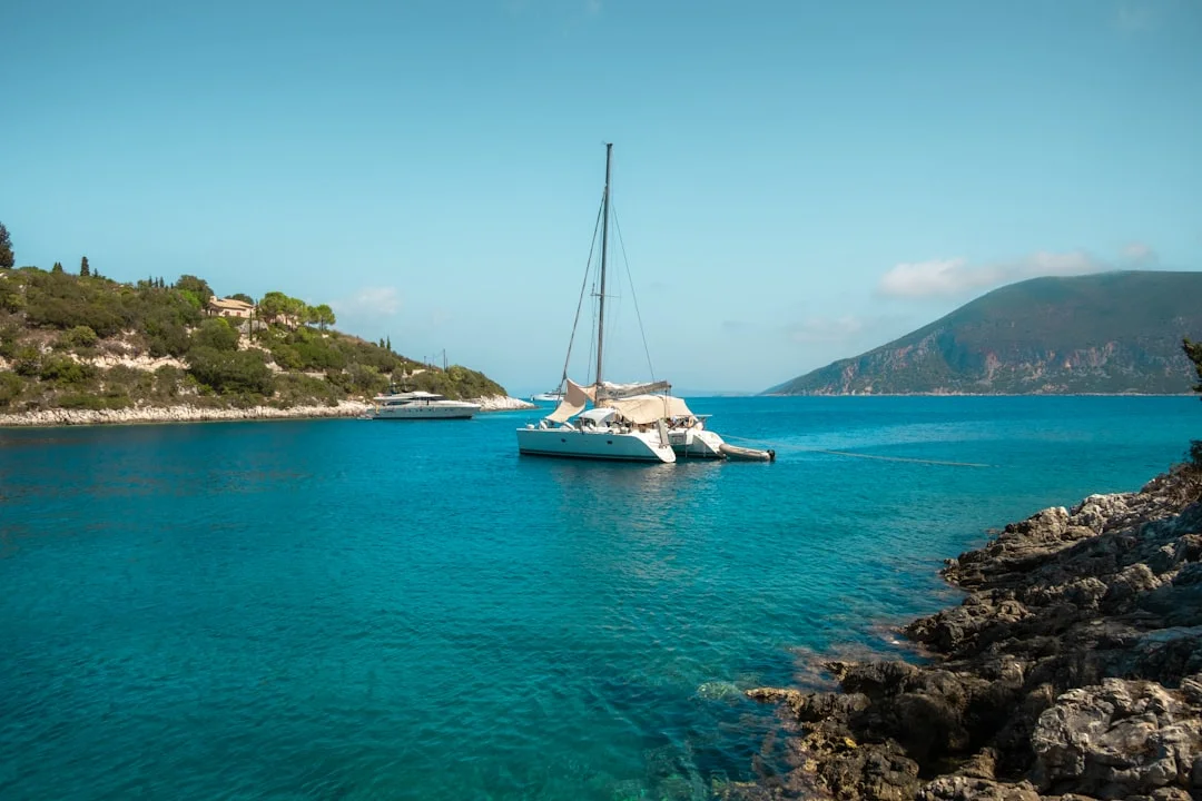 A small charter fleet at anchor in a protected bay with calm water and surrounding hills