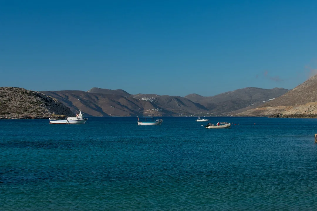 Busy Greek quay at sunset with yachts stern-to and crew handling lines