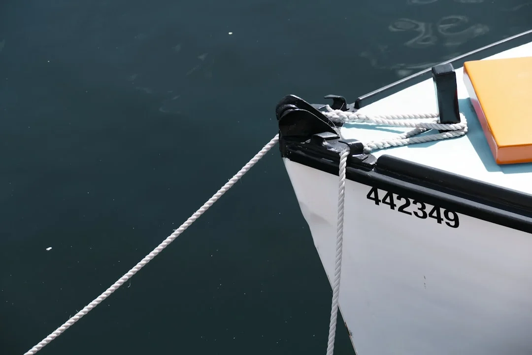 crew using boat hook to retrieve pickup tail while keeping slack off the water