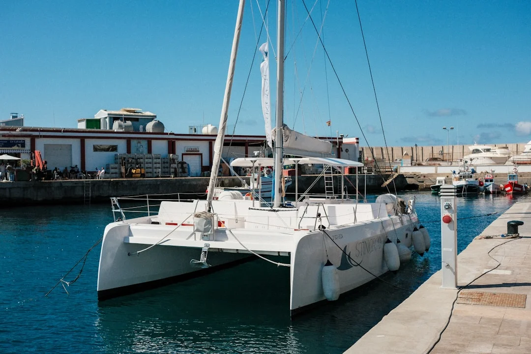 Diagram-style illustration showing catamaran corner contact points and beam clearance in a slip