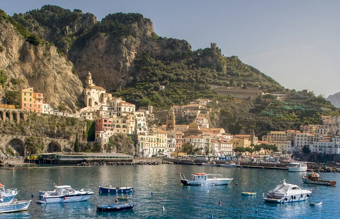 Procida waterfront with small craft and anchored yachts at golden hour