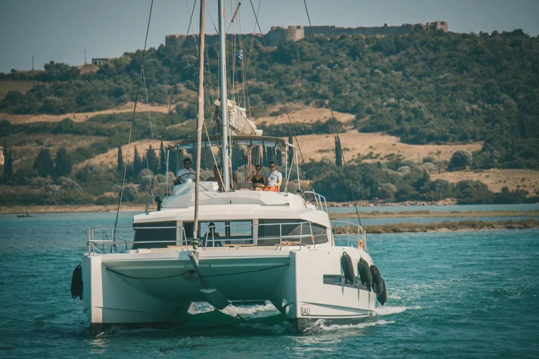 Catamaran aborting a docking attempt—backing out with clear fairway space and crew standing by with lines