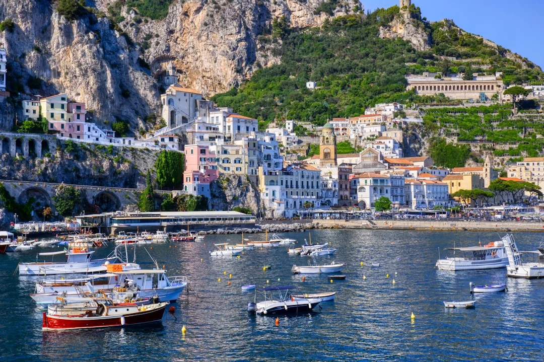 Capri Marina Grande entrance with ferry traffic and a yacht standing off outside the harbor
