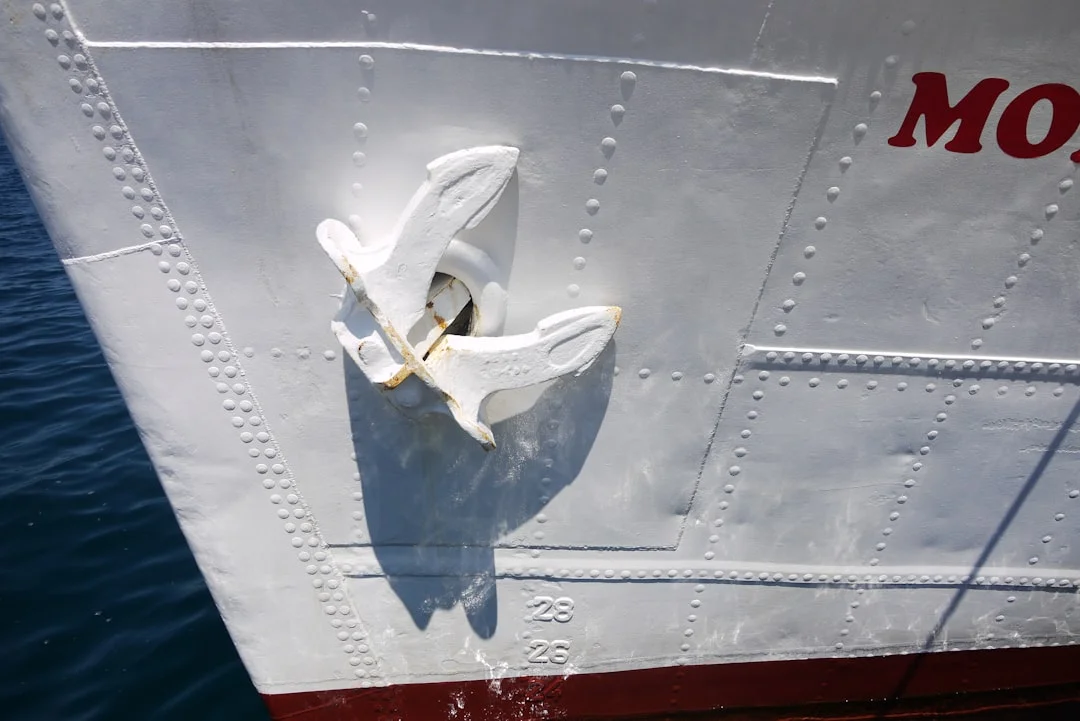 Stern view of a sailboat backing into a slip with visible prop wash turbulence