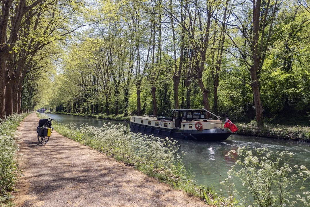 Close-up of a PK marker on a canal bank with a hire boat passing slowly