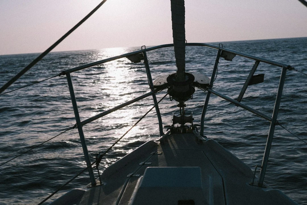 Merchant ship on hazy horizon with sailboat in foreground, illustrating detectability problem