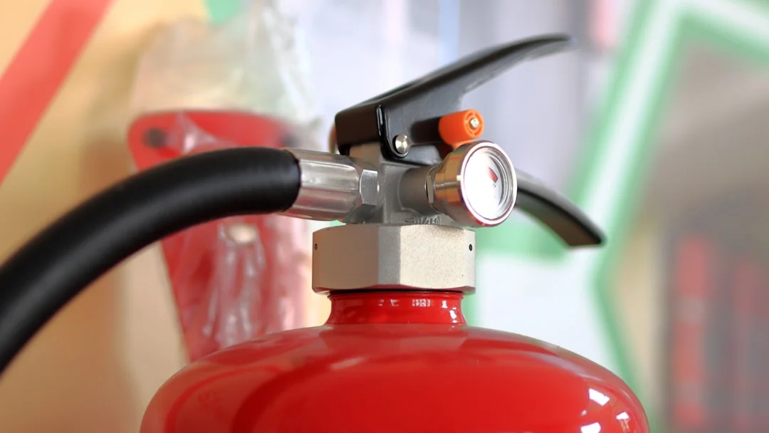 Close-up of extinguisher service tag, manufacture date, and gauge in green